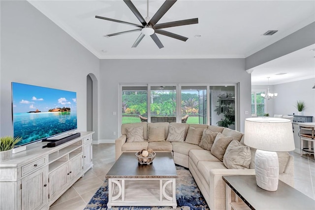 tiled living room with ceiling fan with notable chandelier and ornamental molding