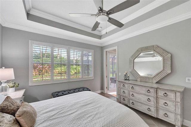 bedroom with a raised ceiling, access to exterior, ceiling fan, and multiple windows