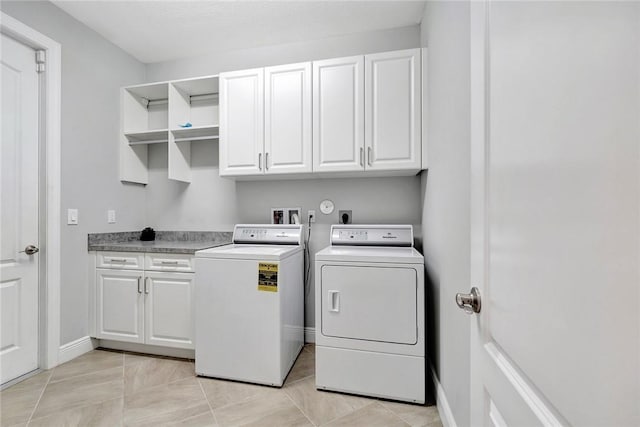 washroom with washer and clothes dryer, cabinets, and light tile patterned floors