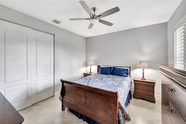 bedroom featuring light tile patterned floors, a closet, and ceiling fan