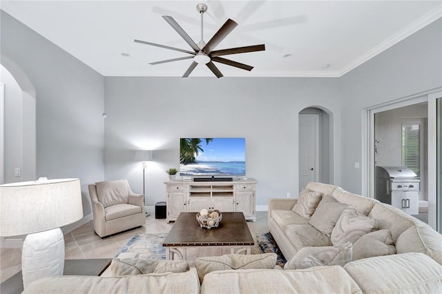 tiled living room with ceiling fan and ornamental molding