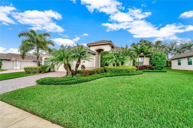 mediterranean / spanish home with a garage and a front yard