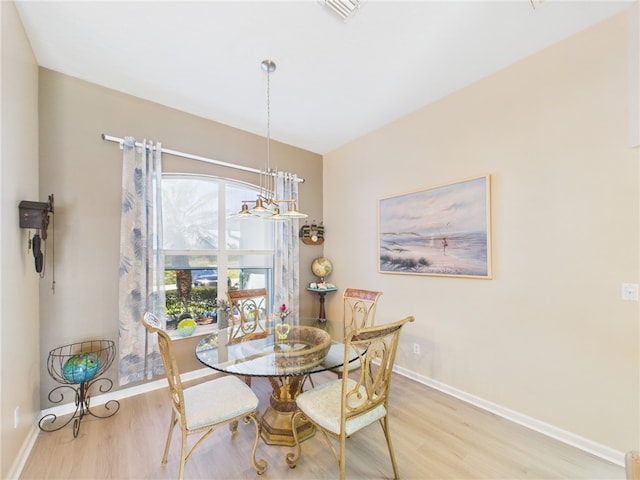 dining room with visible vents, baseboards, a notable chandelier, and wood finished floors