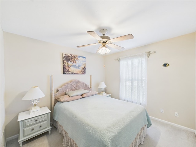 bedroom with light carpet, ceiling fan, and baseboards