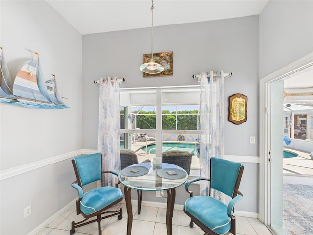 tiled dining space featuring baseboards and plenty of natural light