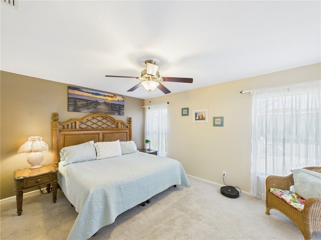 bedroom with baseboards, light carpet, visible vents, and ceiling fan