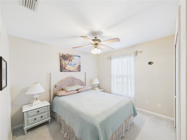 bedroom with visible vents, baseboards, light colored carpet, and a ceiling fan