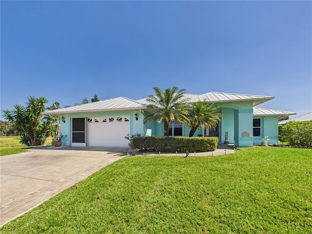 single story home with a front yard, driveway, a standing seam roof, stucco siding, and a garage