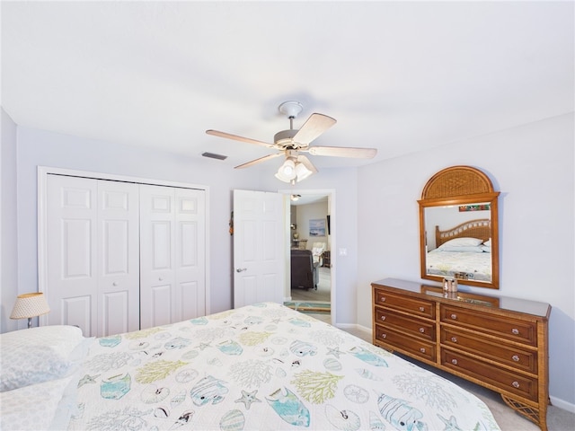 carpeted bedroom featuring a closet, baseboards, visible vents, and a ceiling fan