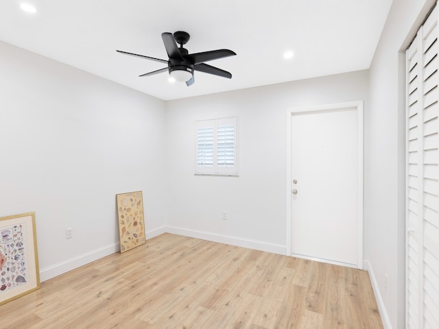 empty room with ceiling fan and light hardwood / wood-style flooring