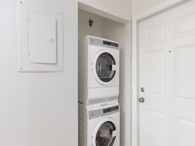 laundry room featuring stacked washer and clothes dryer and electric panel