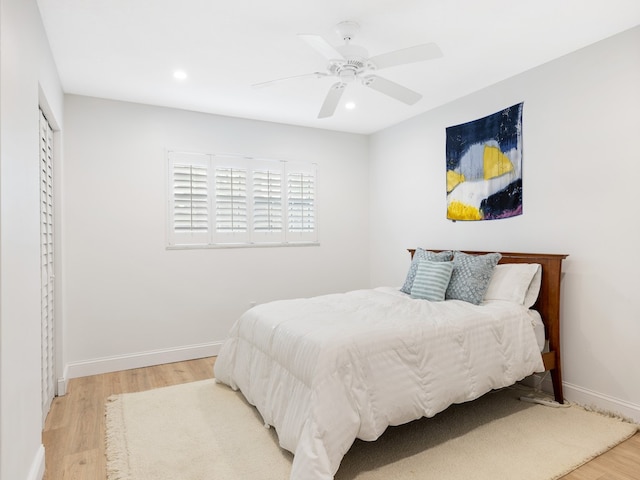 bedroom with light hardwood / wood-style floors, ceiling fan, and a closet