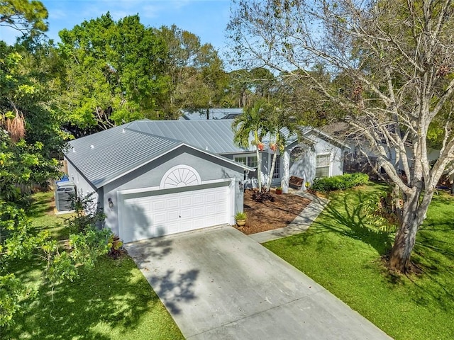 single story home featuring metal roof, driveway, a front lawn, and a garage