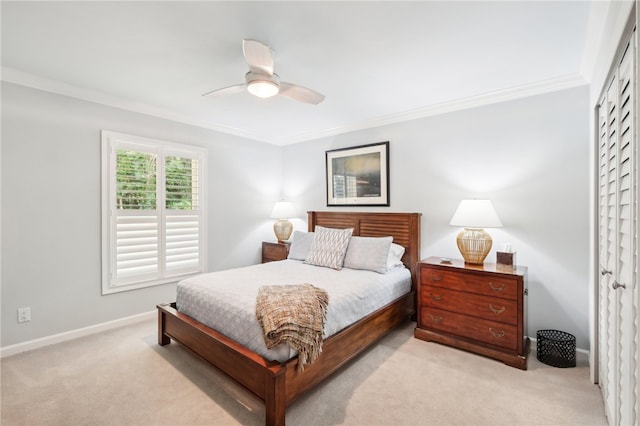 carpeted bedroom featuring ceiling fan, crown molding, and a closet