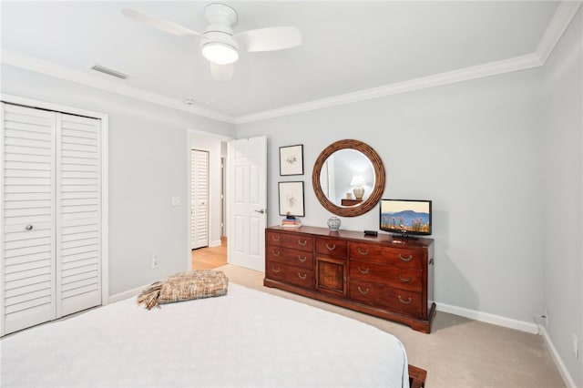 carpeted bedroom featuring ceiling fan, crown molding, and a closet