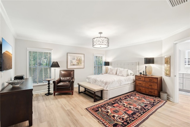 bedroom featuring connected bathroom, light hardwood / wood-style flooring, and multiple windows