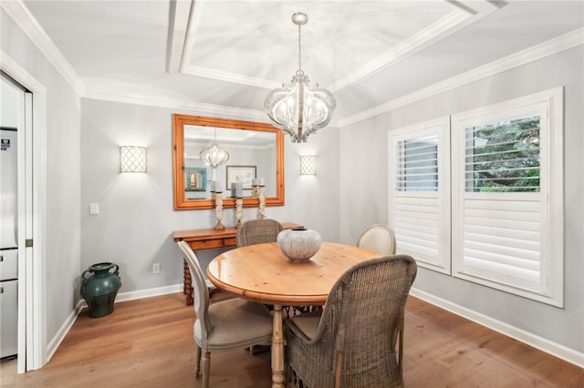 dining room featuring hardwood / wood-style flooring, crown molding, and a notable chandelier