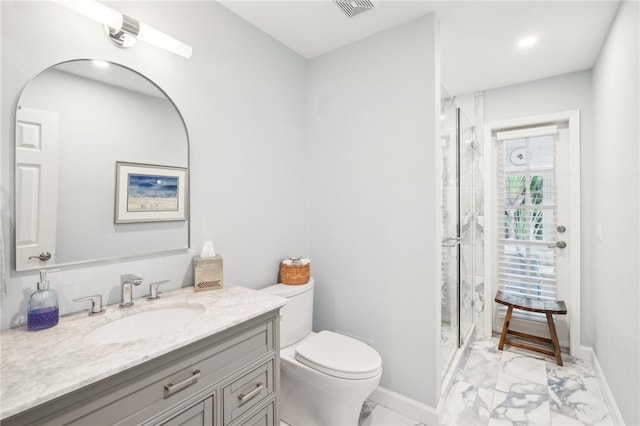 bathroom featuring vanity, toilet, and a shower with shower door