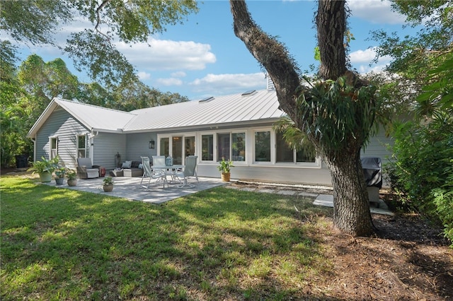 back of house with a yard and a patio