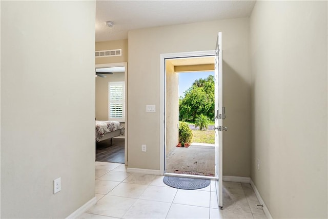 foyer entrance featuring light tile patterned floors, visible vents, and baseboards