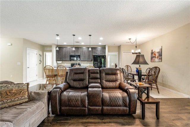 living room featuring baseboards, recessed lighting, dark wood-style flooring, a textured ceiling, and a chandelier