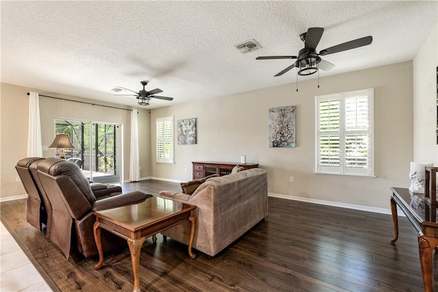 living room with plenty of natural light, dark wood-style floors, visible vents, and baseboards