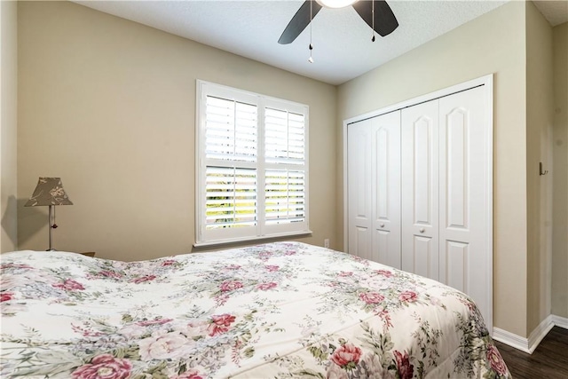 bedroom featuring a closet, baseboards, dark wood-type flooring, and a ceiling fan