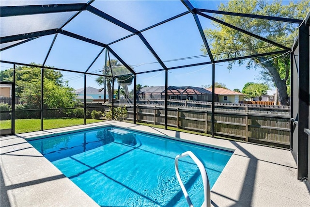 pool featuring a patio area, a residential view, glass enclosure, and fence private yard