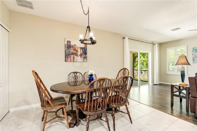 dining space with visible vents, baseboards, a chandelier, and light tile patterned flooring