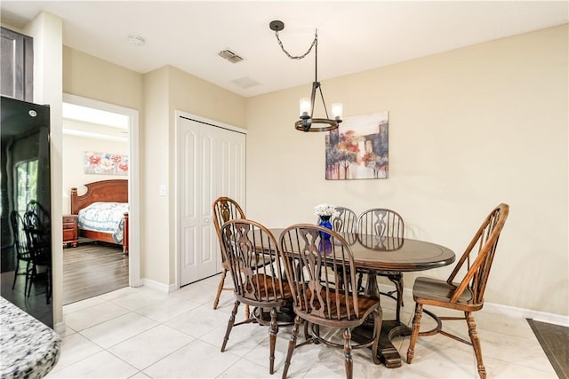 dining room featuring light tile patterned floors, visible vents, baseboards, and an inviting chandelier