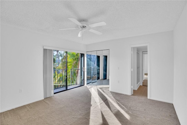 unfurnished bedroom featuring connected bathroom, access to exterior, ceiling fan, a textured ceiling, and light carpet