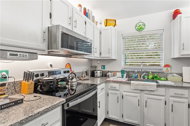 kitchen featuring stainless steel appliances, white cabinets, sink, and light stone counters