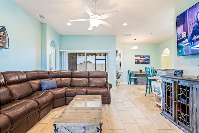 living area featuring arched walkways, visible vents, a ceiling fan, and recessed lighting