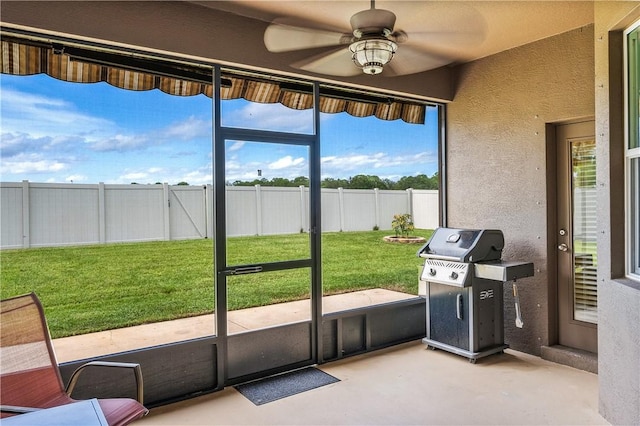 doorway to outside featuring ceiling fan, concrete floors, and a textured wall