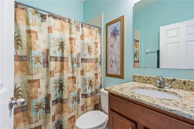 full bathroom with vanity, curtained shower, and toilet