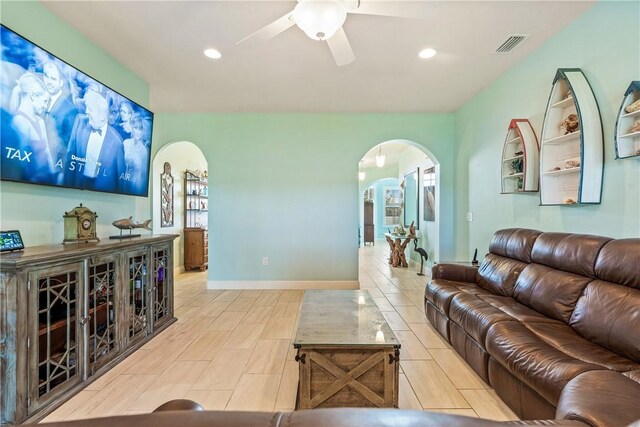 living room with a ceiling fan, arched walkways, baseboards, visible vents, and recessed lighting