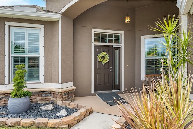 entrance to property featuring stucco siding
