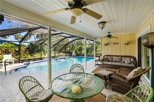 view of swimming pool featuring an outdoor hangout area, glass enclosure, and a patio area