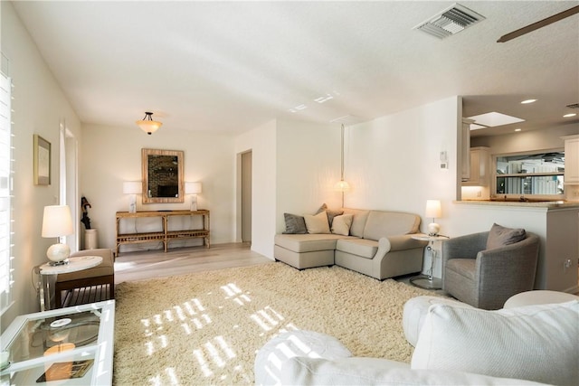 living room with ceiling fan and light wood-type flooring