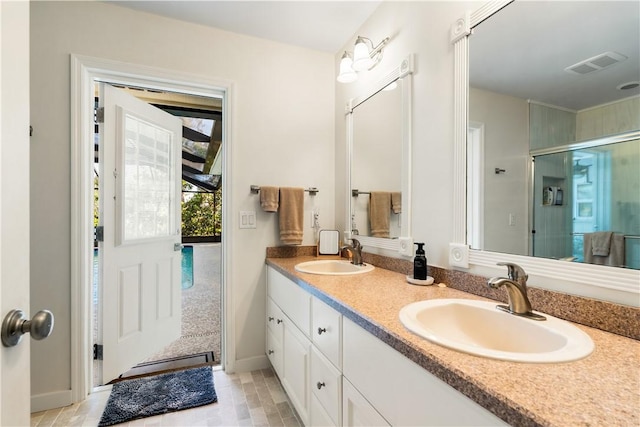 bathroom with vanity and a shower with door