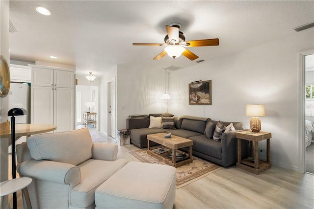 living room with ceiling fan and light hardwood / wood-style flooring