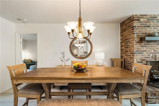 dining area with light hardwood / wood-style floors and a notable chandelier