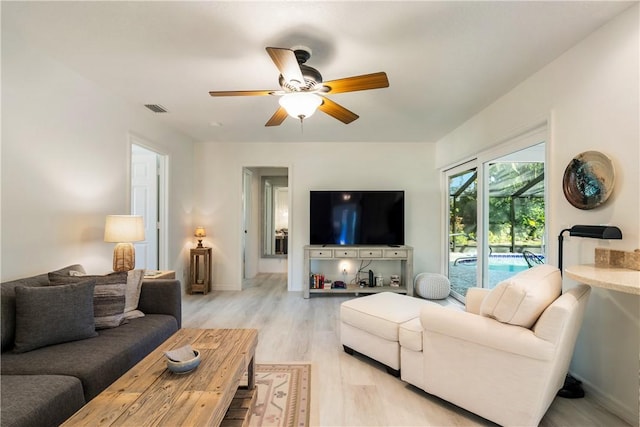 living room with ceiling fan and light hardwood / wood-style floors