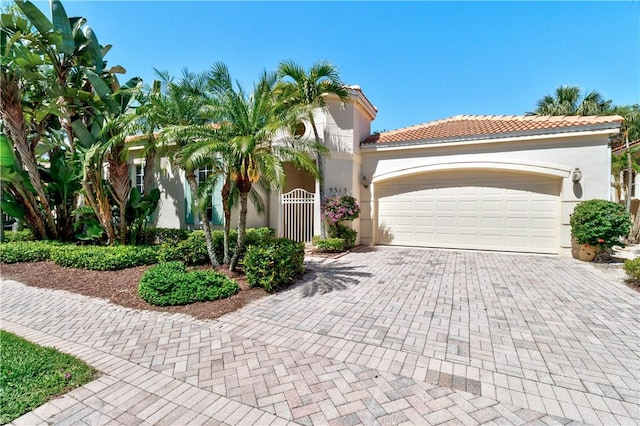 9515 E Maiden Ct, Vero Beach, FL 32963 - mediterranean / spanish house with a tiled roof, stucco siding, decorative driveway, and a garage