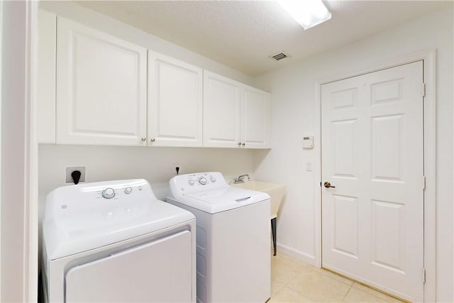 9515 E Maiden Ct, Vero Beach, FL 32963 - clothes washing area featuring cabinet space, washing machine and dryer, light tile patterned floors, and visible vents