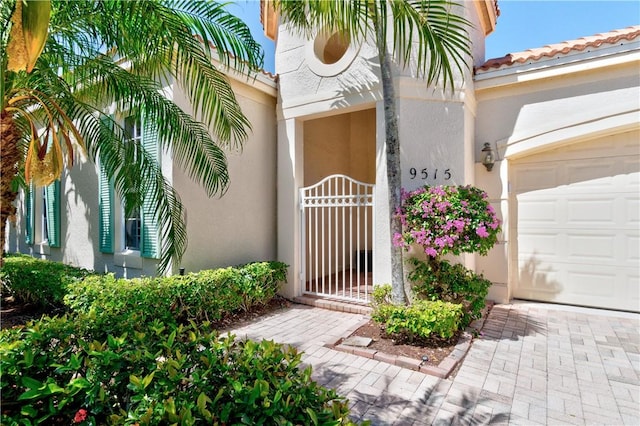 9515 E Maiden Ct, Vero Beach, FL 32963 - entrance to property featuring an attached garage and stucco siding