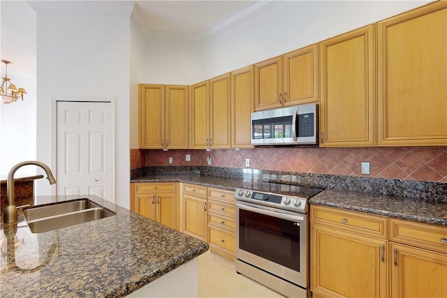9515 E Maiden Ct, Vero Beach, FL 32963 - kitchen featuring a sink, dark stone counters, ornamental molding, decorative backsplash, and appliances with stainless steel finishes