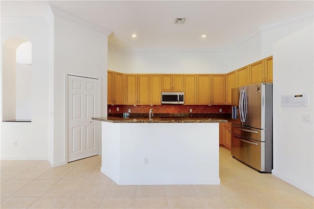 9515 E Maiden Ct, Vero Beach, FL 32963 - kitchen with light tile patterned floors, stainless steel appliances, crown molding, visible vents, and backsplash