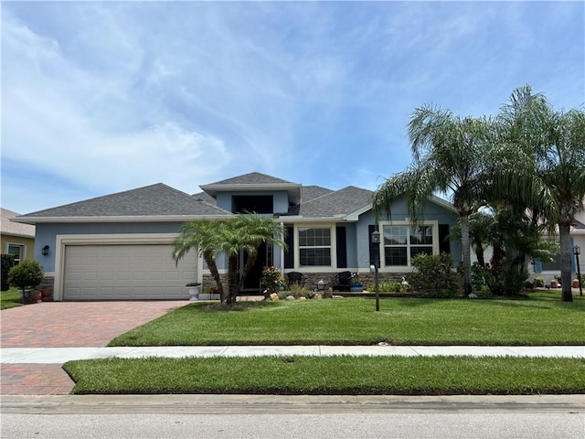 582 Gossamer Wing Way, Sebastian, FL 32958 - ranch-style home featuring a garage, decorative driveway, a front yard, stucco siding, and stone siding