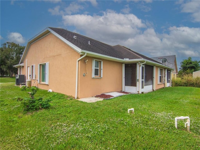 992 Seneca Ave, Sebastian, FL 32958 - rear view of property with a lawn, stucco siding, and a sunroom
